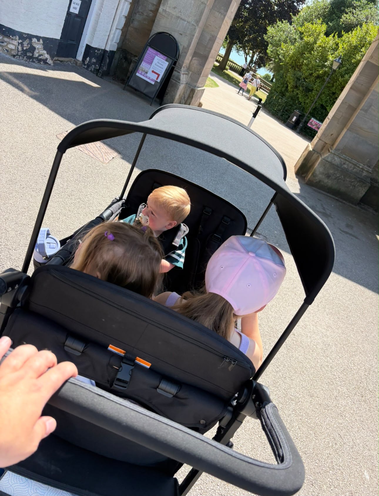 Three children seated in the WonderFold wagon exploring a town